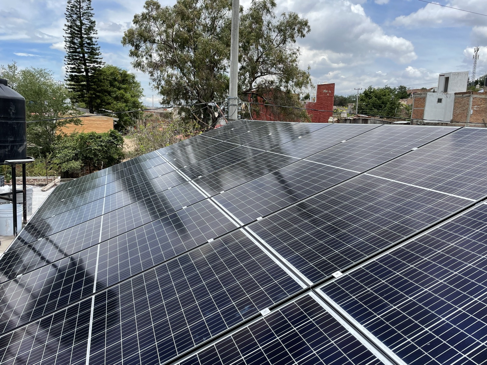 Arreglo de paneles solares en comercio con tinaco